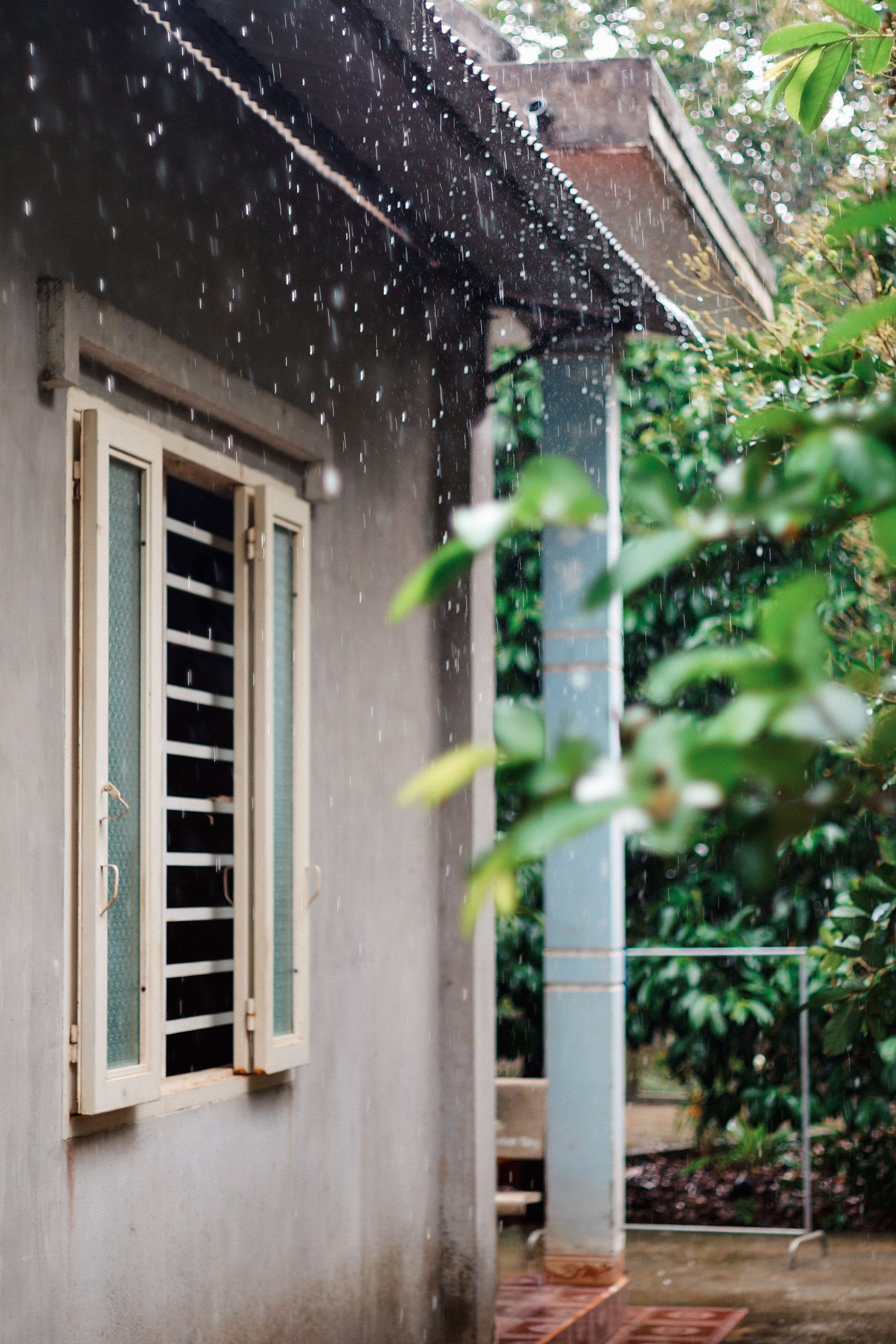 Rain pouring off the edge of a roof during a heavy storm