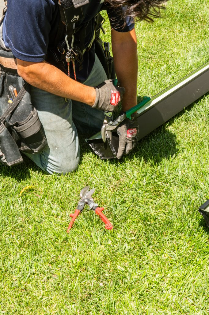 Snipping a gutter end to size on the lawn