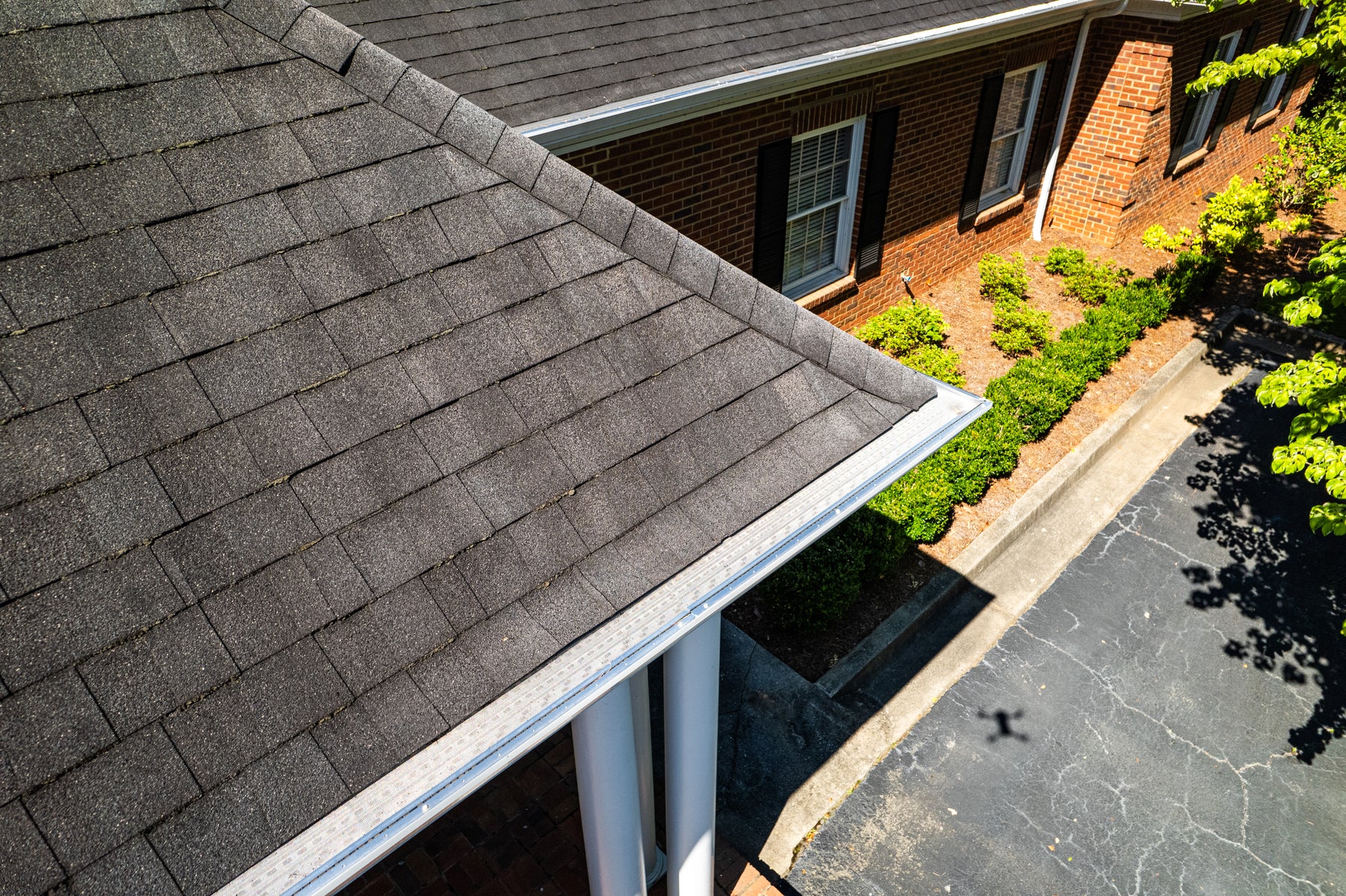 New white gutters fitted with metal guards along a roofline